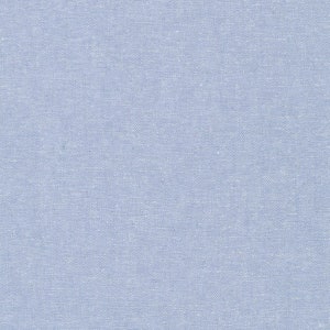 May include: A close-up of a light blue fabric with a woven texture. The fabric has a subtle, even color and a slightly rough surface. The weave is visible, creating a grid-like pattern across the material.