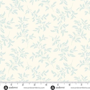 May include: A cream-colored fabric featuring a repeating pattern of light blue leafy branches. A ruler is visible at the bottom edge, showing measurements in inches from 0 to 7, indicating the scale of the botanical print on the textile.