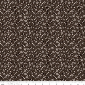 May include: A brown fabric with a repeating pattern of white interlocking circles and small white dots.