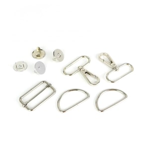 May include: A set of silver metal hardware for bags and purses. The set includes two D-rings, two half-circle rings, a rectangular buckle, two swivel clasps, and four magnetic snap closures.