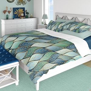 May include: A white ceramic mug with a black handle and the text "But First, Coffee" in a bold, black font. The mug is filled with a dark liquid, likely coffee, and sits on a light-colored surface.