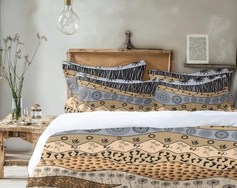 May include: A patterned bed set featuring a duvet cover and pillowcases. The design includes horizontal stripes with animal silhouettes, geometric shapes, and tribal patterns in shades of tan, black, and gray. The bedding is on a bed with a wooden headboard.