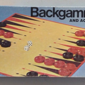 May include: A vintage Milton Bradley game box featuring a backgammon board with red and black playing pieces. The box also includes the text "Backgammon and Acey-Deucy".