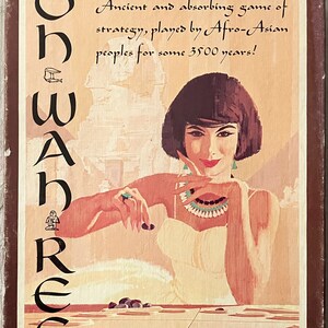 May include: A vintage game box cover featuring a woman in a white dress playing a board game called "Oh Wah-Ree". The box cover has a brown background with white text that reads "Ancient and absorbing game of strategy, played by Afro-Asian peoples for some 3500 years!" and "1976 The Avalon Hill Game Co. Baltimore, MD 21214 Formerly a Minnesota Mining & Mfg Game."