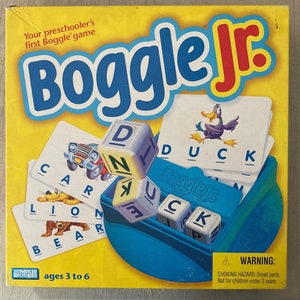 May include: A yellow box with the words "Boggle Jr." in large, colorful letters. The box features a blue and white game board with letter cubes and a picture of a duck. The box also includes the text "Your preschooler's first Boggle game" and "ages 3 to 6".