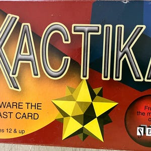 May include: XACTIKA board game box with the text "BEWARE THE LAST CARD" and "ages 12 & up." The box features a yellow starburst and the text "From the makers of SET."