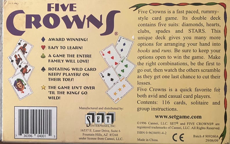 Puede incluir: Caja del juego de cartas Five Crowns. La caja es de color beige con el t&iacute;tulo del juego en morado. La parte posterior de la caja tiene detalles del juego e ilustraciones de cartas. El juego incluye 116 cartas y es adecuado para solitario o juego en grupo.
