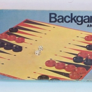 May include: A vintage Milton Bradley Backgammon game box with a red, black, and white game board and dice. The box has a blue background with white text that reads "Backgammon and Acey-Deucy".