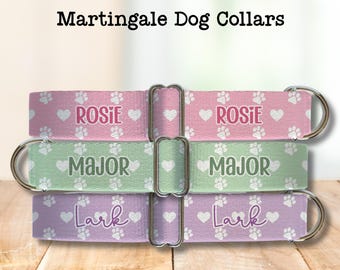 Puede incluir: Tres collares Martingale personalizados para perros en rosa, verde y morado. Cada collar presenta un nombre, huellas de patas y corazones. El collar rosa dice "Rosie", el collar verde dice "Major" y el collar morado dice "Lark".