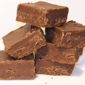 Puede incluir: Una pila de seis cuadrados de fudge de chocolate, cada uno con una textura y forma ligeramente diferentes, dispuestos sobre una superficie blanca.