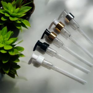 May include: Five different lotion pump bottles with clear tubes. The pumps are white, black, gold, and silver.