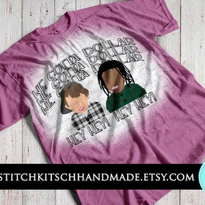 May include: A pink t-shirt with a graphic design featuring two cartoon figures and the words "GOTTA DOLLAR" and "HEY HEY!" in black. The Etsy shop URL is at the bottom.