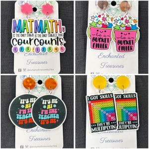 May include: Four pairs of colourful earrings with different designs. The first pair features a pink and purple design with the text "MATMATH IS THE ONLY SUBJECT THAT COURCOUNTS 123 12345". The second pair features a pink bucket with the text "be a BUCKET FILLER". The third pair features a black circle with the text "IT'S ME *HI* I'M THE TEACHER IT'S ME". The fourth pair features a rainbow design with the text "I GOT SKILLS THEY'RE MULTIPLYIN".