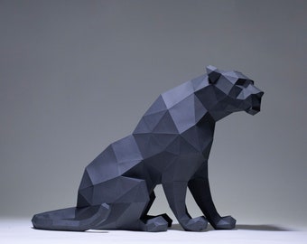 May include: A black papercraft sculpture of a panther sitting with its head turned to the side. The sculpture is made of folded paper and has a geometric design.