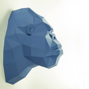 May include: A blue papercraft sculpture of a gorilla head, with a detailed, geometric design.