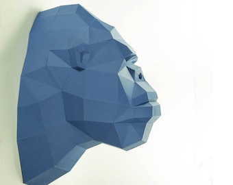 Pode incluir: Uma escultura de papel azul de uma cabeça de gorila, com um design geométrico detalhado.