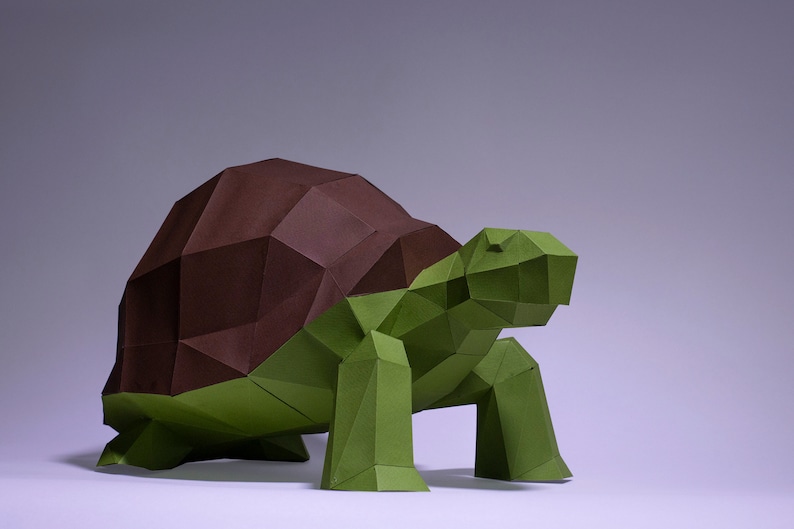 May include: An origami tortoise sculpture made from green and brown paper. The tortoise has a detailed, geometric design.