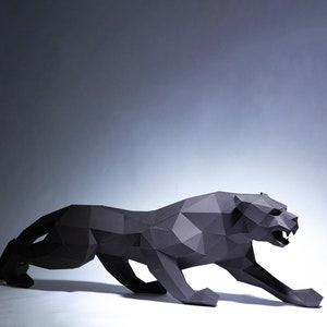 Könnte beinhalten: Eine schwarze Origami-Panther-Skulptur in einer hockenden Pose. Die Skulptur ist aus gefaltetem Papier gefertigt und hat ein realistisches Aussehen.