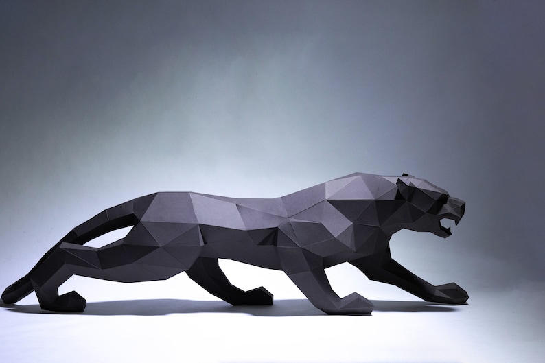 May include: A black papercraft panther sculpture in a crouching pose. The sculpture is made of folded paper and has a geometric design.