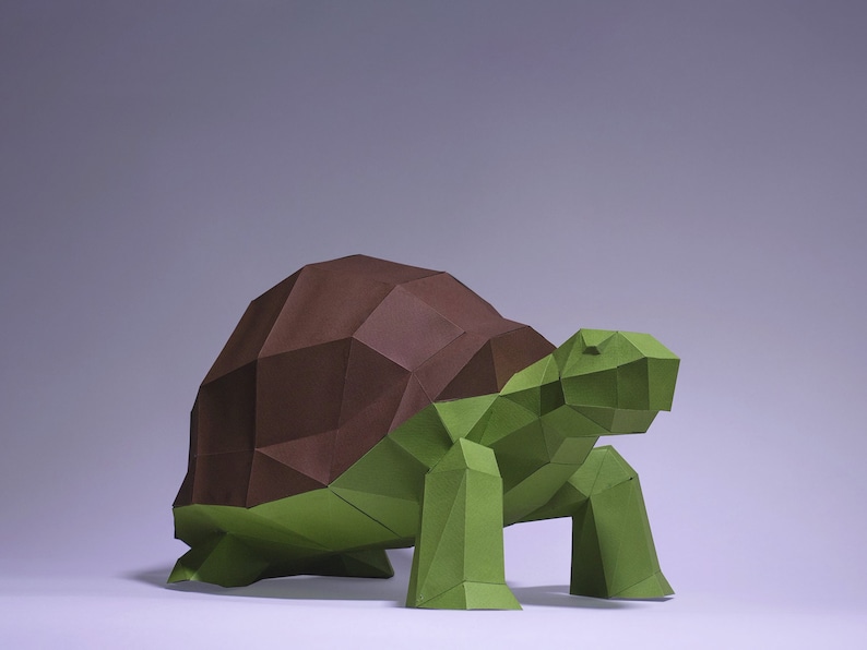 May include: A papercraft model of a turtle with a brown shell and green legs and head.