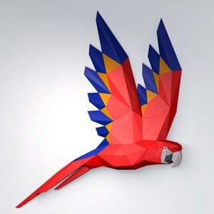 Puede incluir: Un loro de origami rojo, azul y amarillo en vuelo. El loro está hecho de papel y tiene un diseño geométrico detallado.