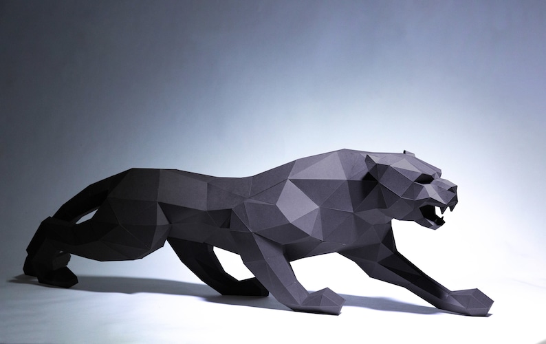 May include: A black papercraft sculpture of a panther in a crouching pose. The sculpture is made of folded paper and has a realistic appearance.