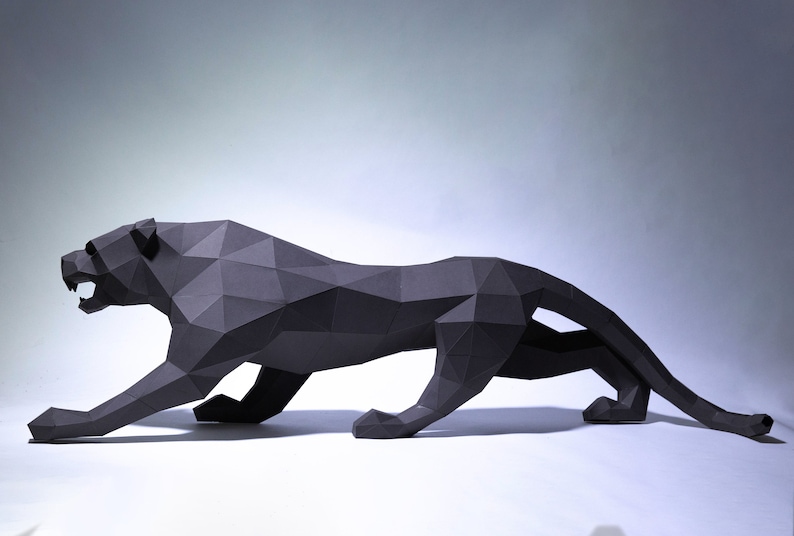 May include: A black papercraft sculpture of a panther in a crouching pose. The sculpture is made of folded paper and has a geometric design.