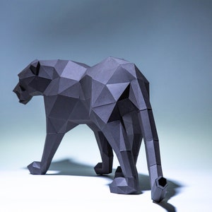 May include: A black papercraft sculpture of a panther, standing on a white surface. The panther is made of many small triangles, giving it a geometric look.