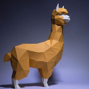 Op de afbeelding: Een papieren model van een alpaca, gemaakt van bruin en wit papier. De alpaca staat op een lichtpaarse ondergrond.