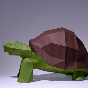 May include: An origami tortoise sculpture made from green and brown paper. The tortoise has a detailed shell.