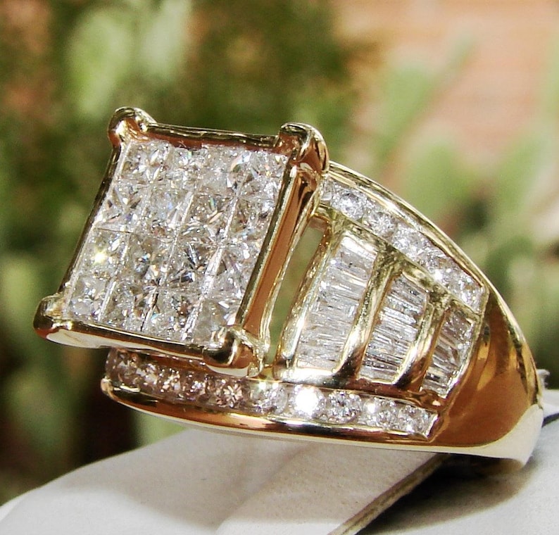 May include: A gold ring featuring a large square-shaped centre stone surrounded by smaller diamonds. The band is also set with diamonds in a baguette shape.
