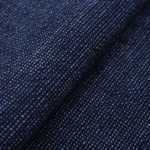 May include: Close-up of a dark blue fabric with a textured, woven pattern. The fabric has a subtle sheen and a slightly rough feel.