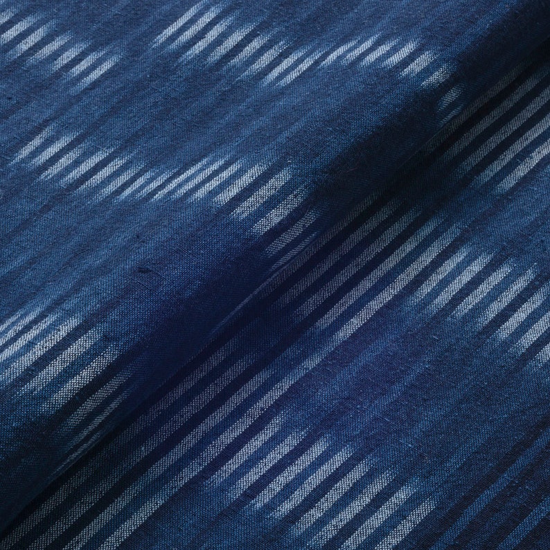 May include: Blue fabric with a white stripe pattern. The fabric has a textured, woven look.