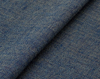 May include: Close-up of a folded piece of blue fabric with a textured weave. The fabric has a speckled appearance with lighter flecks throughout the darker blue material. The weave is tight and appears durable, suitable for upholstery or clothing.