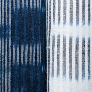 May include: Two pieces of fabric with a striped pattern. One piece is a dark blue fabric with white stripes, and the other is a white fabric with dark blue stripes.