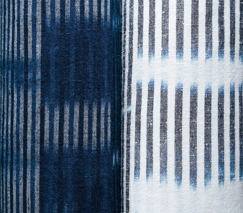 May include: Two pieces of fabric with a striped pattern. One piece is a dark blue fabric with white stripes, and the other is a white fabric with dark blue stripes.