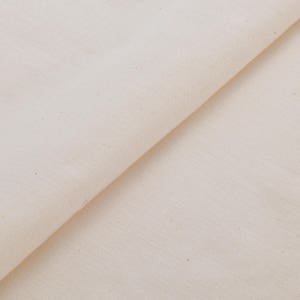 May include: A close-up of a plain white fabric with a subtle texture. The fabric is folded in half, creating a diagonal line across the image.