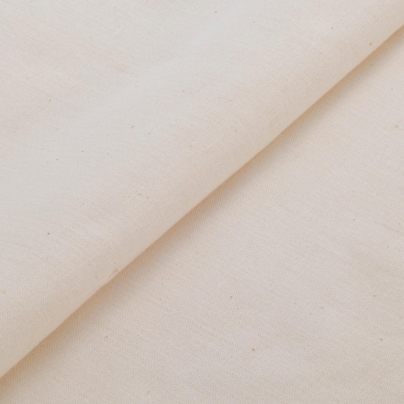 May include: A close-up of a plain white fabric with a subtle texture. The fabric is folded in half, creating a diagonal line across the image.
