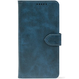 Pode incluir: Uma capa de telefone de couro azul com um acabamento texturizado. A capa tem um fecho magnético e costuras nas bordas. Projetada para proteger o telefone de arranhões e danos.