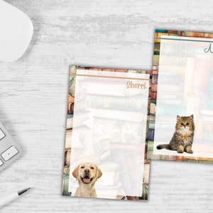 May include: Two personalized notepad sets with a book stack background. One notepad features a golden retriever puppy and the name "Sherri". The other notepad features a fluffy kitten and the name "Ashley".