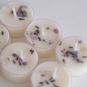 Puede incluir: Seis velas de t&eacute; blancas con lavanda y peque&ntilde;os cristales morados y transparentes incrustados en la cera.