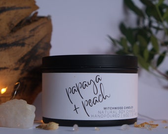 May include: A black candle jar with a white label that reads "papaya + peach" and "Witchwood Candles Natural Soy Candle Handpoured 16oz 35hr".