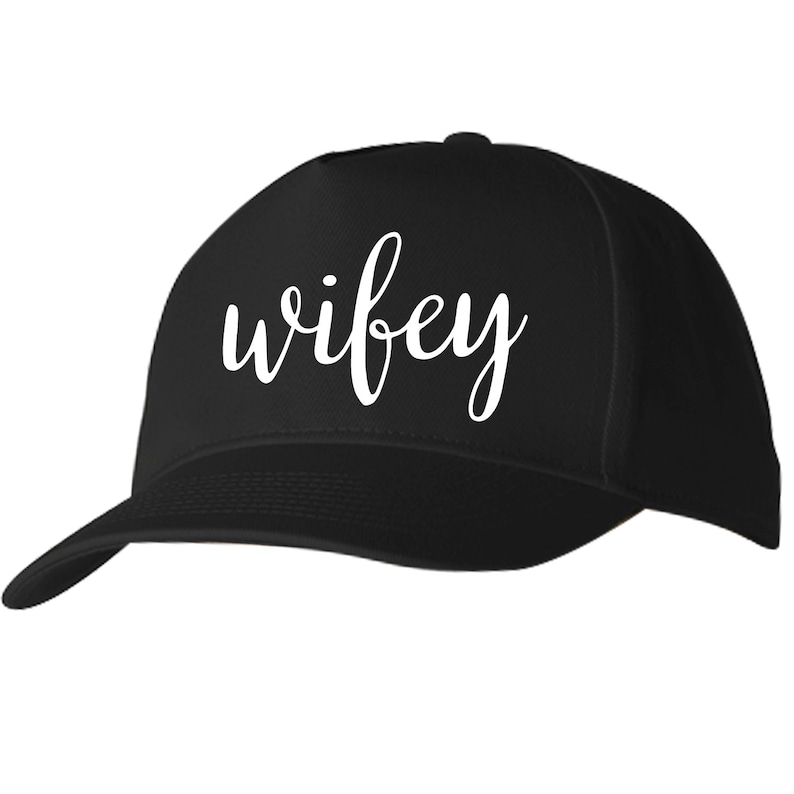 May include: Black baseball cap with the word "wifey" written in white cursive lettering.
