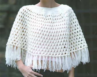 Puede incluir: Poncho de crochet blanco con ribete de flecos. El poncho tiene un tejido suelto y abierto, perfecto para superponer.