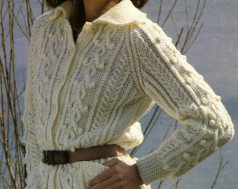 May include: A white knitted cardigan with a cable knit pattern and a brown belt. The cardigan has a collar and a button closure.