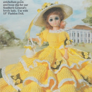 Puede incluir: Un vestido de estilo antebellum de crochet amarillo con ribetes blancos y detalles de flores amarillas para una muñeca de moda de 38 cm. Crochet un elegante vestido de estilo antebellum y una enagua de aro para nuestra encantadora dama del sur. Úsalo con una muñeca de moda de 38 cm.
