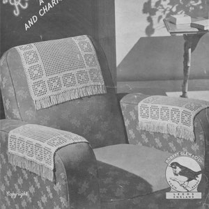 Könnte beinhalten: Ein Schwarzweißbild eines Häkelmusters für einen Stuhlarmlehnen-Set. Das Muster heißt "Robin Perle" und ist ein nützliches und charmantes Set. Das Bild zeigt einen Stuhl mit den Häkelarmlehnenbezügen an Ort und Stelle. Das Bild zeigt auch einen kleinen Tisch mit einer Schachtel darauf und den Schatten einer Pflanze an der Wand.
