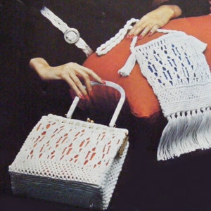 May include: Two white crocheted handbags with fringe. One is a small, rectangular bag with a clasp closure and a white handle. The other is a larger, rectangular bag with a long, fringed strap.