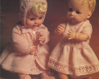 May include: Two pink knitted doll outfits, one with a matching hat and the other with a dress. The outfits are made with a delicate lace pattern and are perfect for a doll with a similar size.