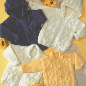 Op de afbeelding: Vier gebreide babytruien in verschillende kleuren: marineblauw, wit, geel en crème. De truien hebben een kabelbreipatroon en zijn allemaal met capuchon.